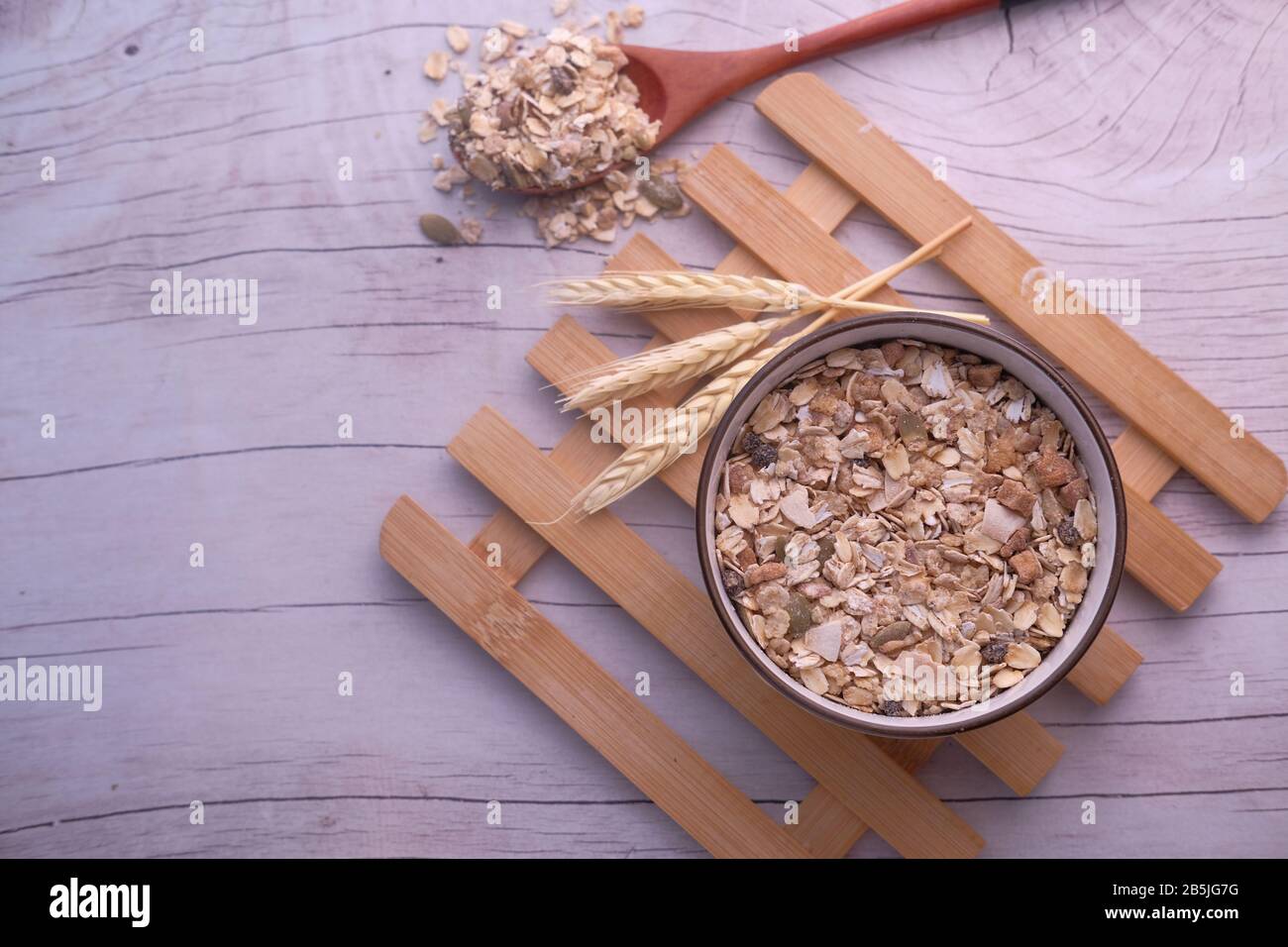 Flocons d'avoine dans un bol en bois et cuillère avec avoine sur table en bois. Banque D'Images