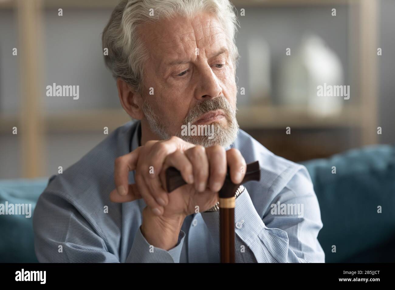 Homme âgé réfléchi avec de la canne perdue dans les pensées se sentant solitaire Banque D'Images