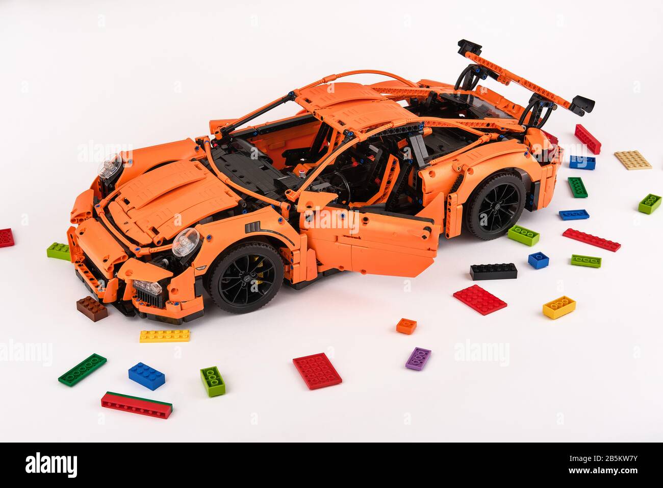 Différentes vues de la voiture LEGO Porsche GT 3 RS orange assemblée entourée de briques lego de rechange Banque D'Images