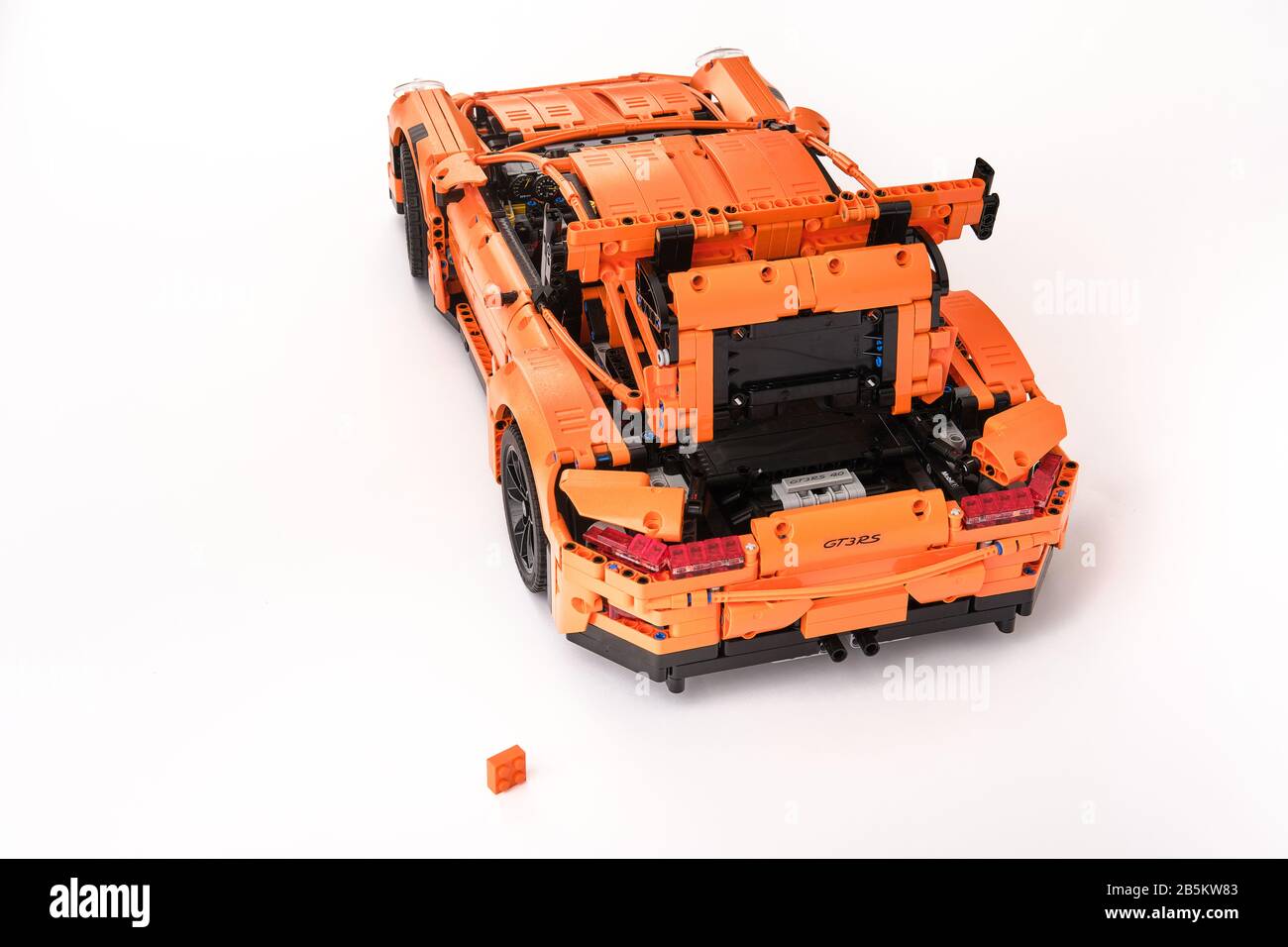 Différentes vues de la voiture LEGO Porsche GT 3 RS orange assemblée avec une brique lego de rechange Banque D'Images