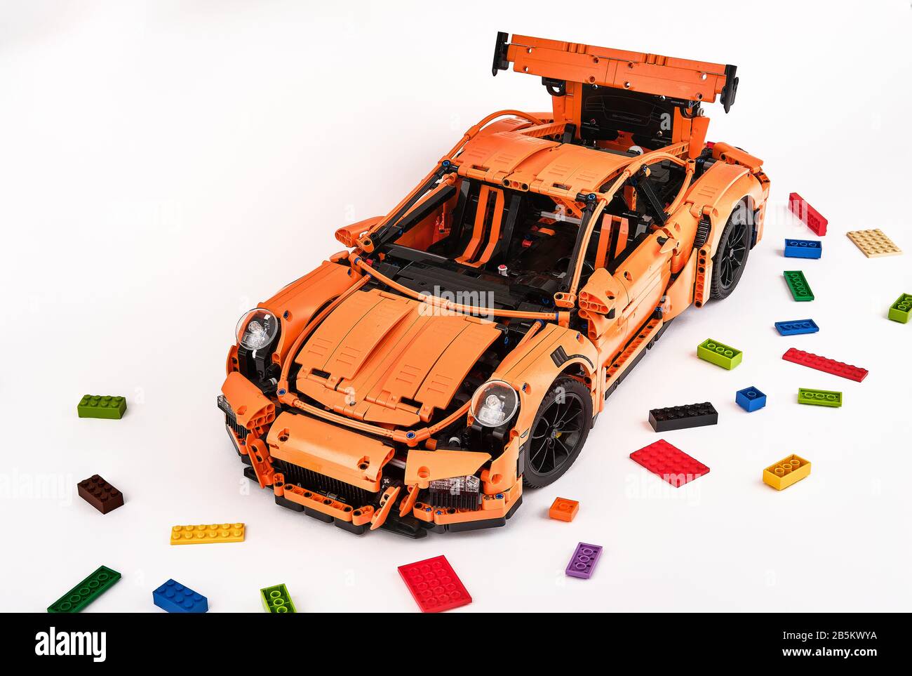 Différentes vues de la voiture LEGO Porsche GT 3 RS orange assemblée entourée de briques lego de rechange Banque D'Images