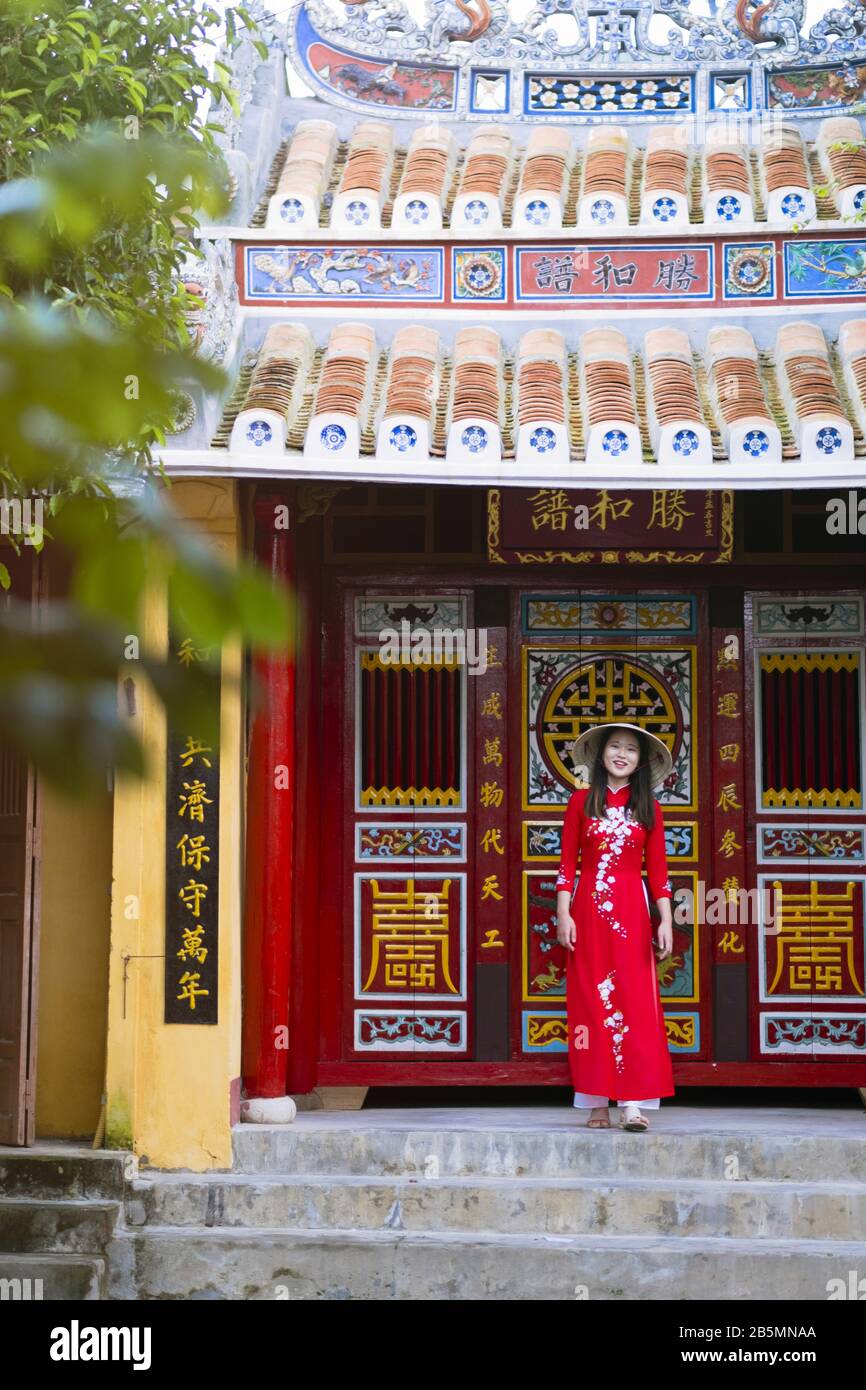 Une jeune femme vietnamienne portant une robe Ao Dai traditionnelle dans les rues du vieux Hoi An Banque D'Images