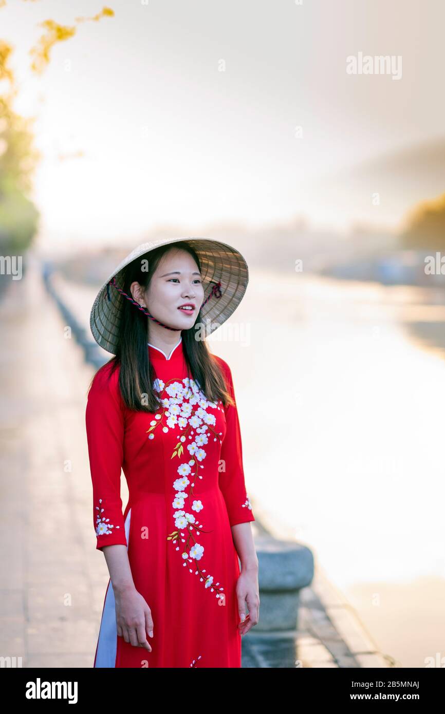 Une jeune femme vietnamienne portant une robe Ao Dai traditionnelle dans les rues du vieux Hoi An Banque D'Images