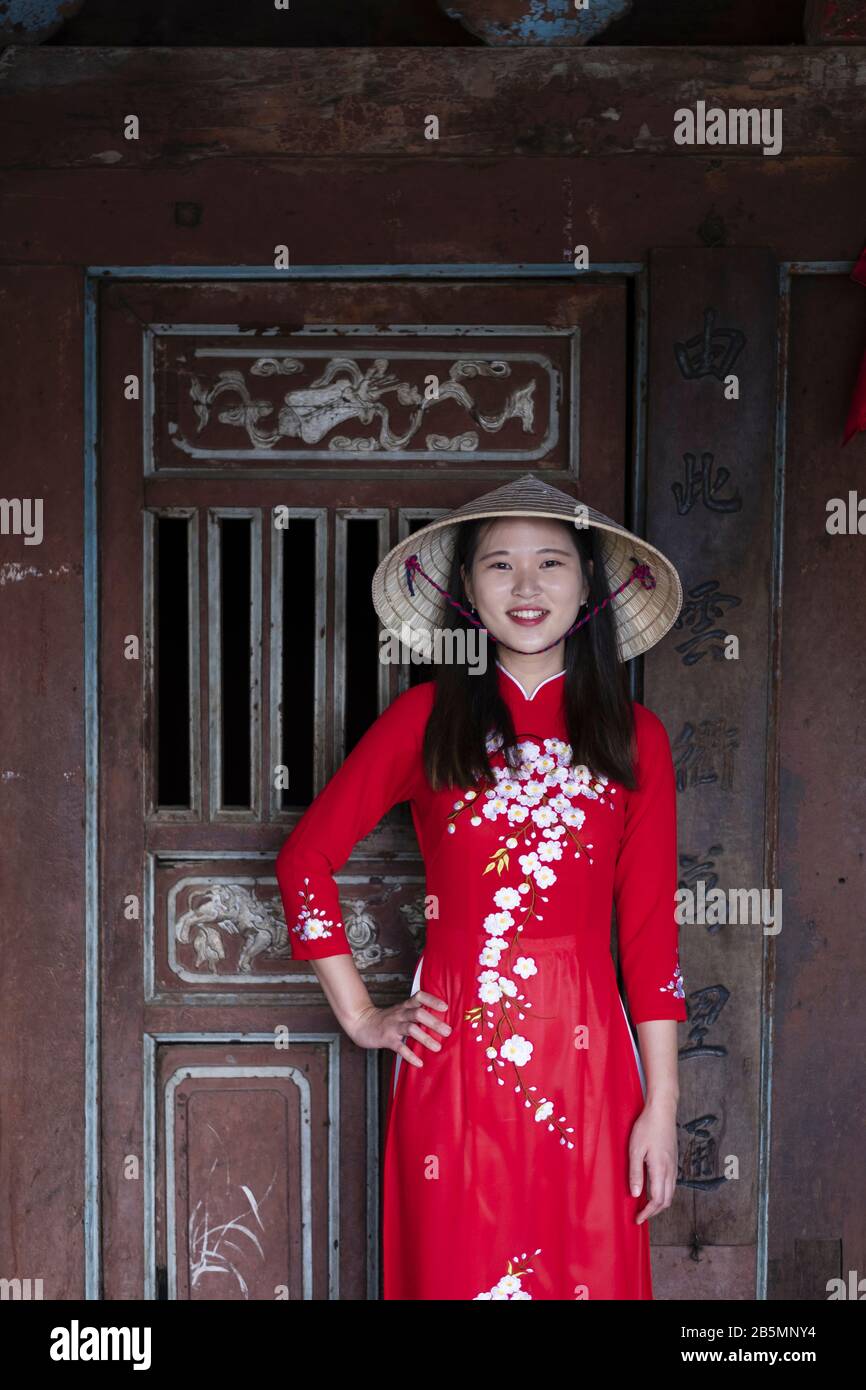 Une jeune femme vietnamienne portant une robe Ao Dai traditionnelle dans les rues du vieux Hoi An Banque D'Images