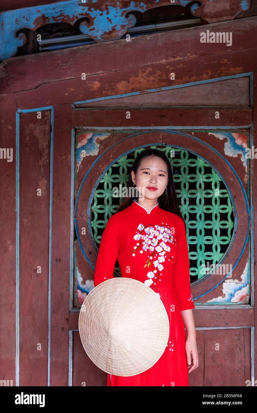 Une jeune femme vietnamienne portant une robe Ao Dai traditionnelle dans les rues de Hoi An, au Vietnam Banque D'Images