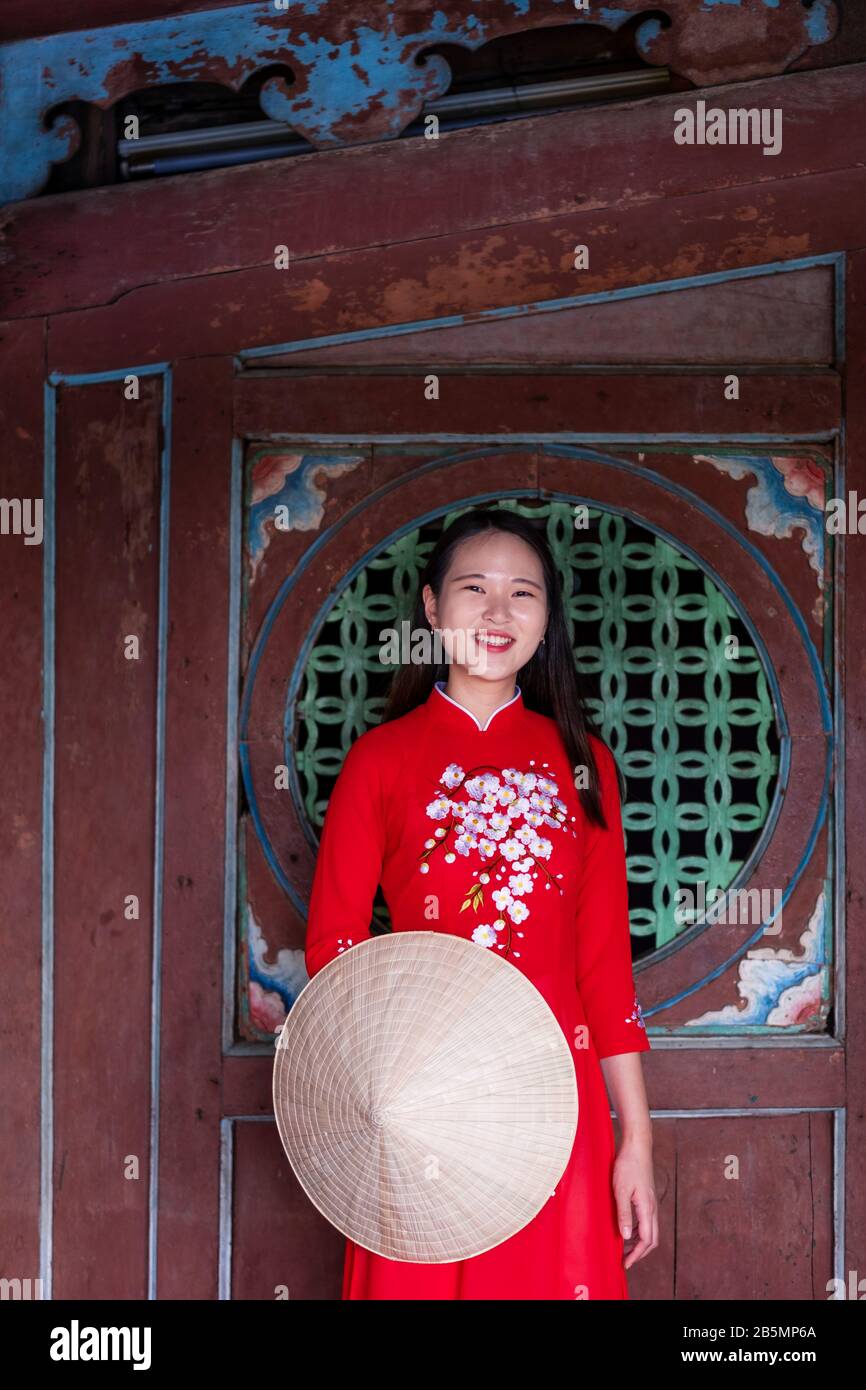 Une jeune femme vietnamienne portant une robe Ao Dai traditionnelle dans les rues de Hoi An, au Vietnam Banque D'Images