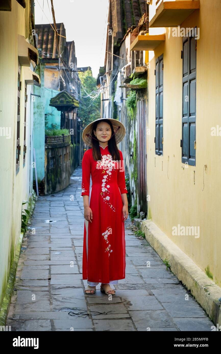 Une jeune femme vietnamienne portant une robe Ao Dai traditionnelle dans  les rues de Hoi An, au Vietnam Photo Stock - Alamy