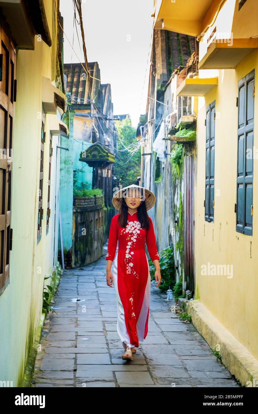 Une jeune femme vietnamienne portant une robe Ao Dai traditionnelle dans les rues de Hoi An, au Vietnam Banque D'Images