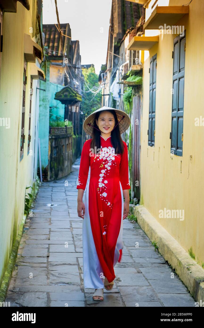 Une jeune femme vietnamienne portant une robe Ao Dai traditionnelle dans les rues de Hoi An, au Vietnam Banque D'Images