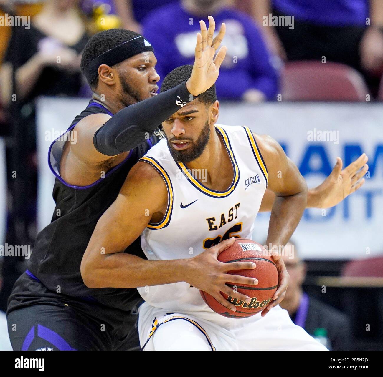 Asheville, Caroline Du Nord, États-Unis. 8 mars 2020. Centre de Buccaneers de l'État du Tennessee est LUCAS n'GUESSAN (25) pousse dans les Catudes de Caroline de l'Ouest Carlos DOTSON (0) pendant les demi-finales du tournoi de la NCAA Southern Conference à Asheville, en Caroline du Nord dimanche 8 mars 2020. Crédit: Rusty Jones/Zuma Wire/Alay Live News Banque D'Images