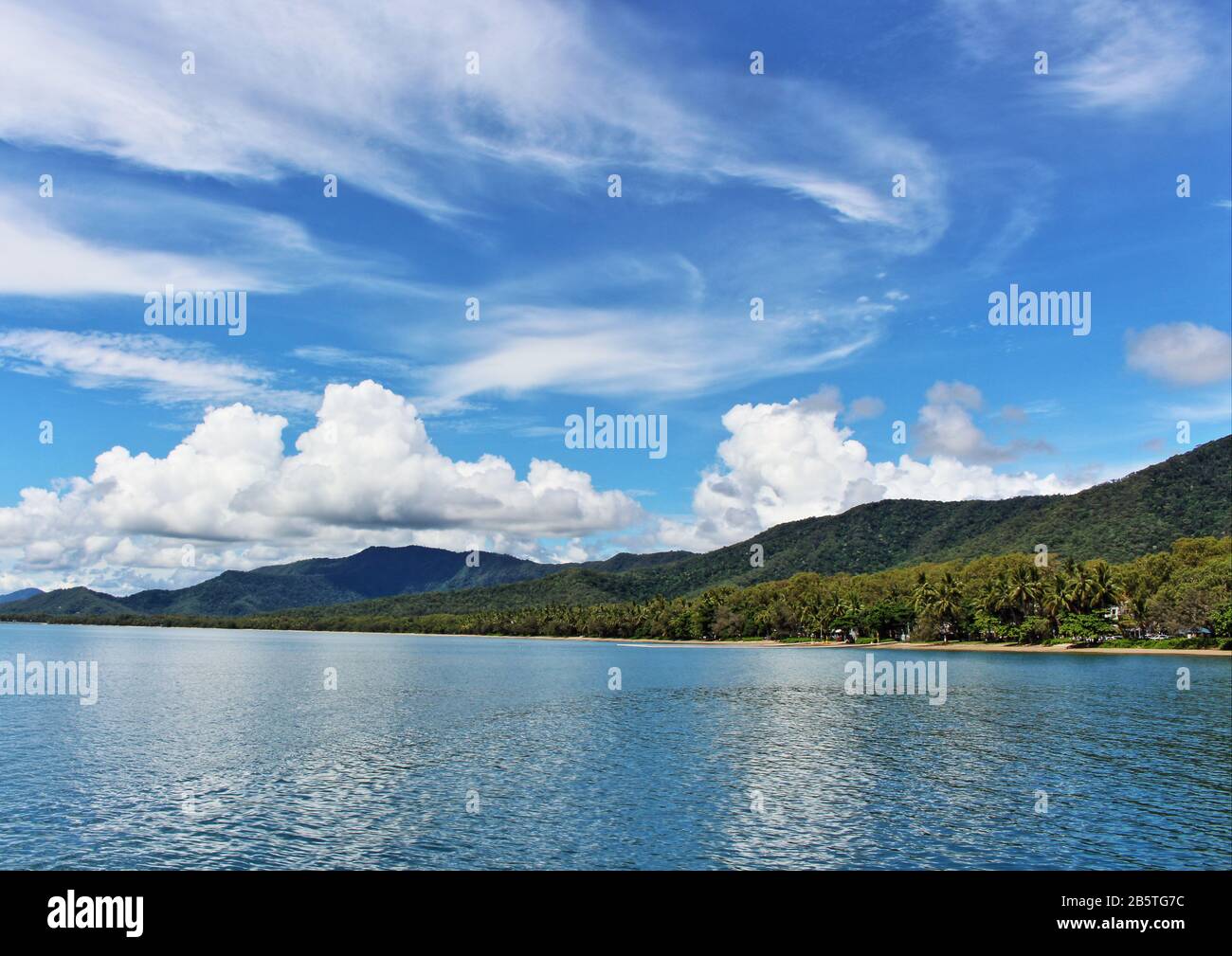 Le ciel bleu, les nuages, l'eau, la verdure, tous sur le point de Palm Cove Banque D'Images