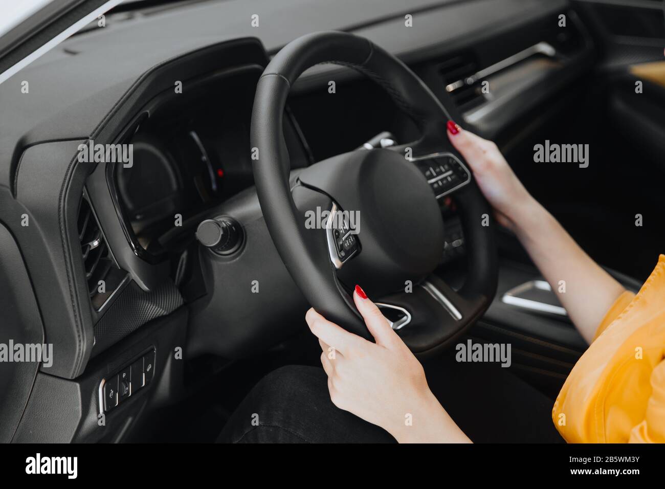 Les mains sur le volant d'une voiture pendant la conduite. Banque D'Images