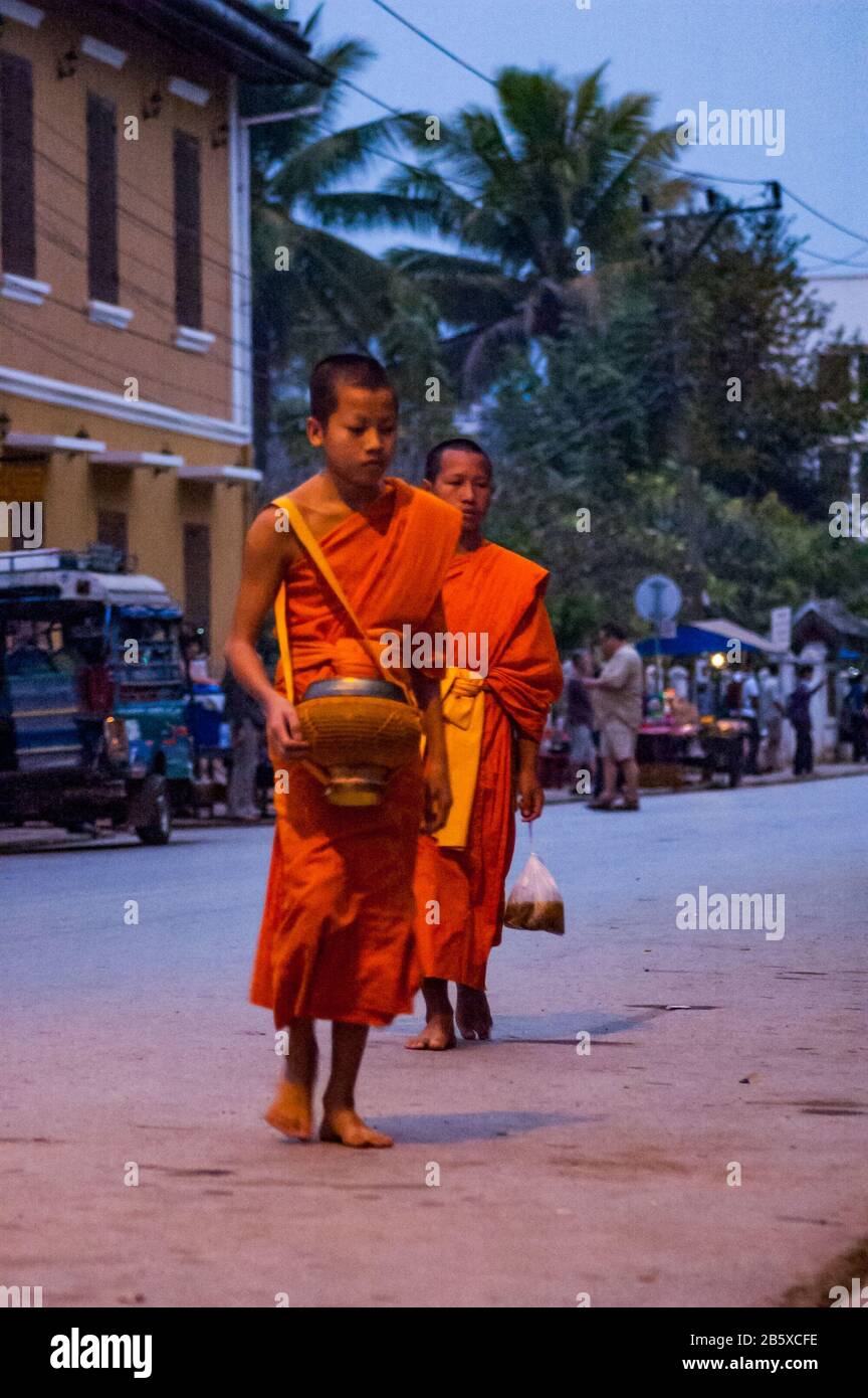 De jeunes moines collectant des alms (tak bat) à Luang Prabang. Banque D'Images