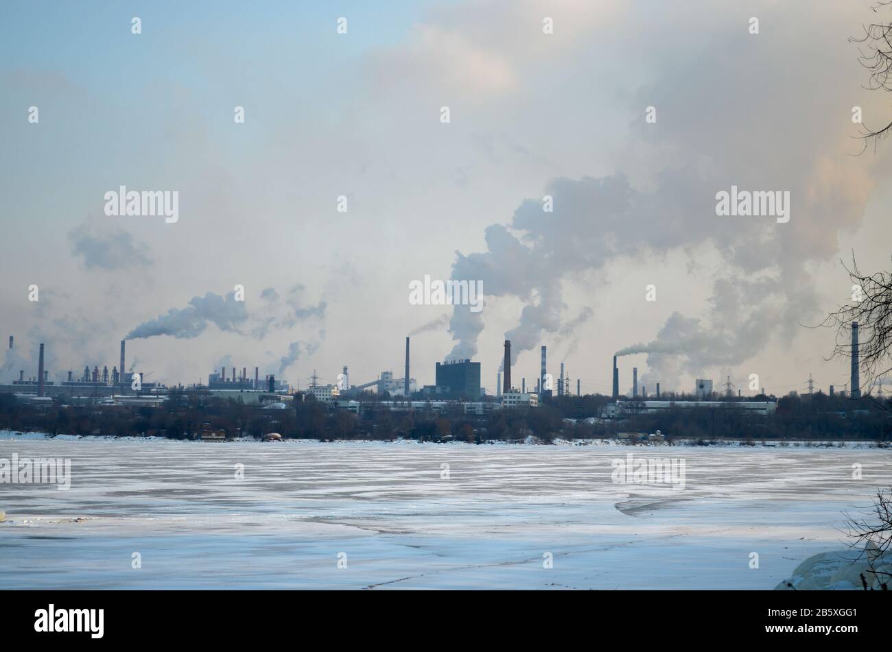 usine de tabac, rivière gelée. paysage industriel ville avec pollution produite Banque D'Images