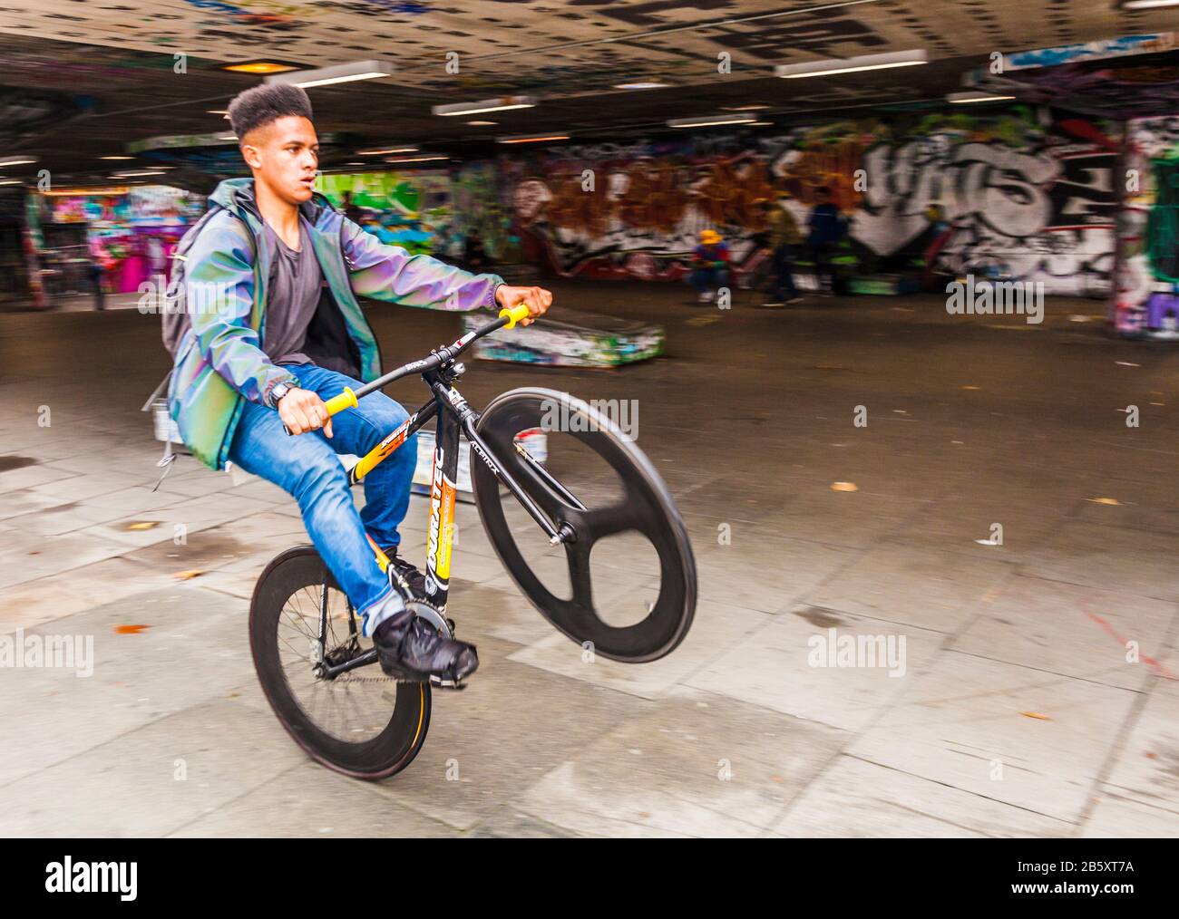 Un jeune noir à vélo sur une roue au parc de skateboard d'Undercroft à Southbank,Londres,Angleterre,Royaume-Uni Banque D'Images