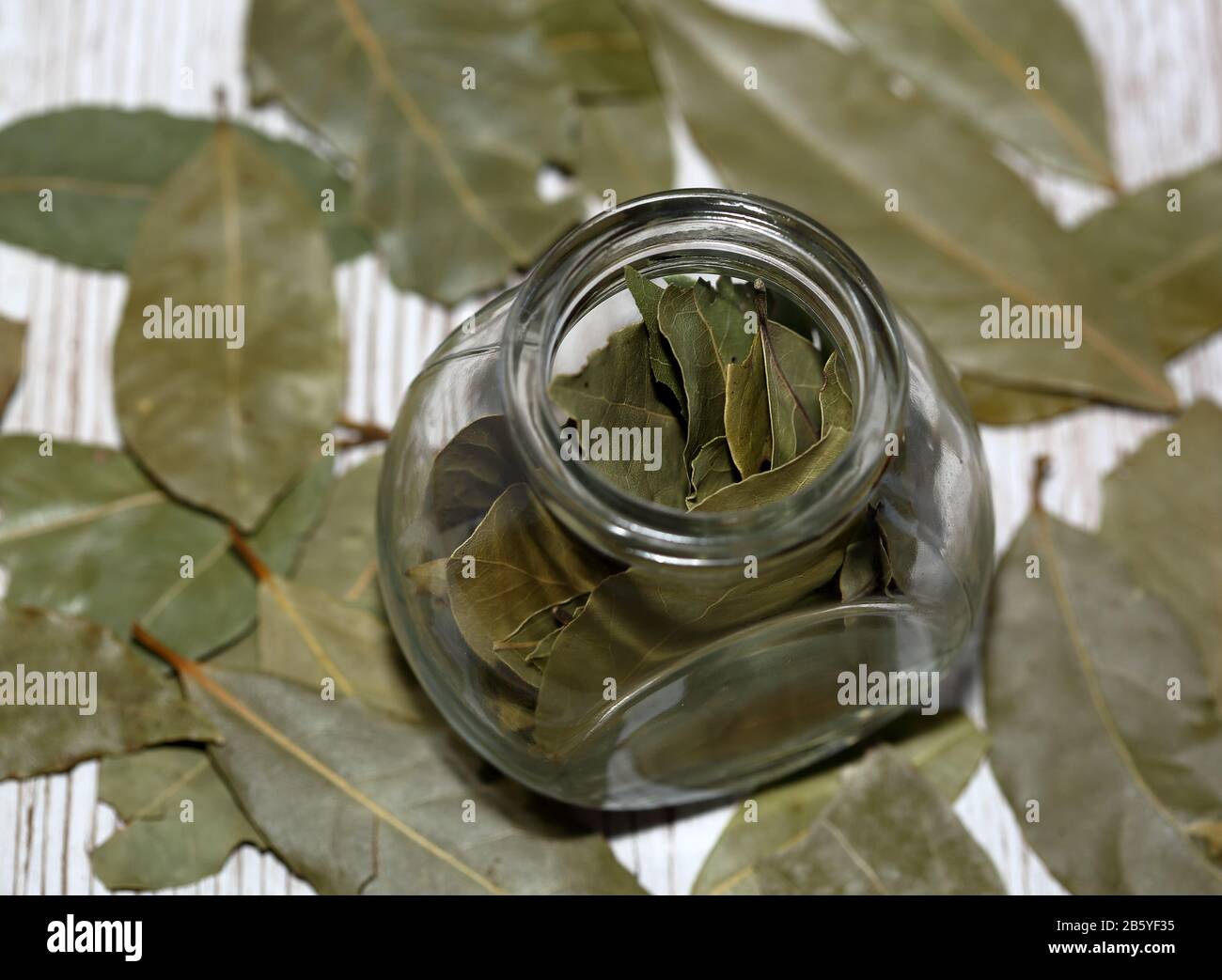 Laurel / Bay laisse dans un petit pot en verre autour de la table en bois dans le doux foyer Banque D'Images