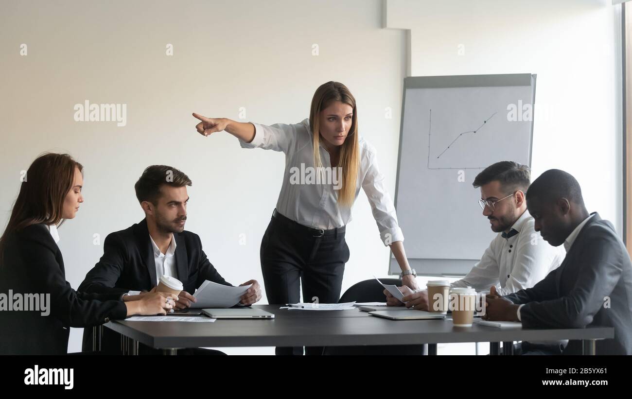 Une femme en colère, le directeur de l'équipe, demande à l'employé de partir. Banque D'Images