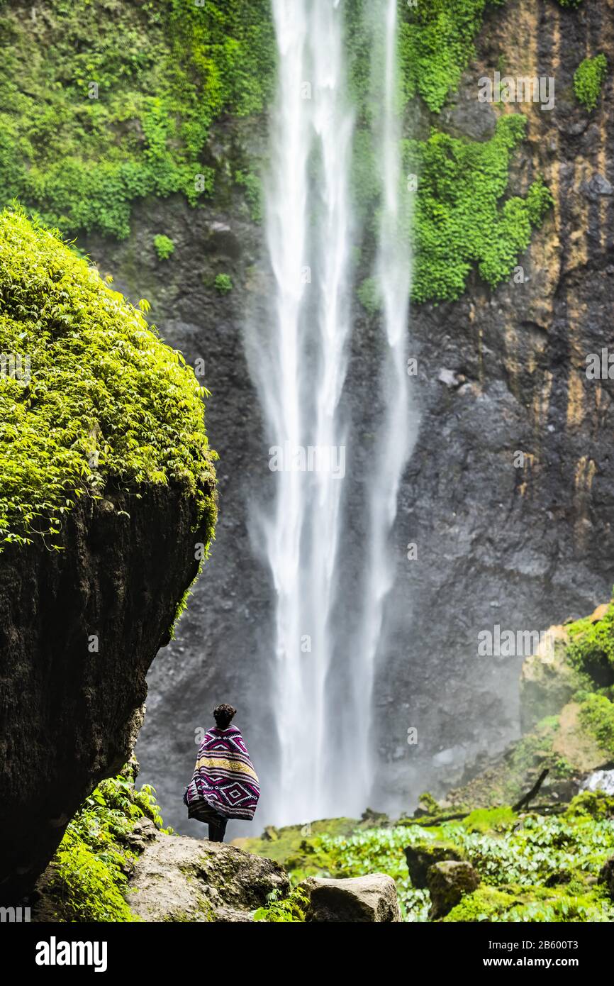 Vue imprenable sur un touriste profitant de la vue sur les chutes de Tumpak Sewu. Indonésie. Banque D'Images