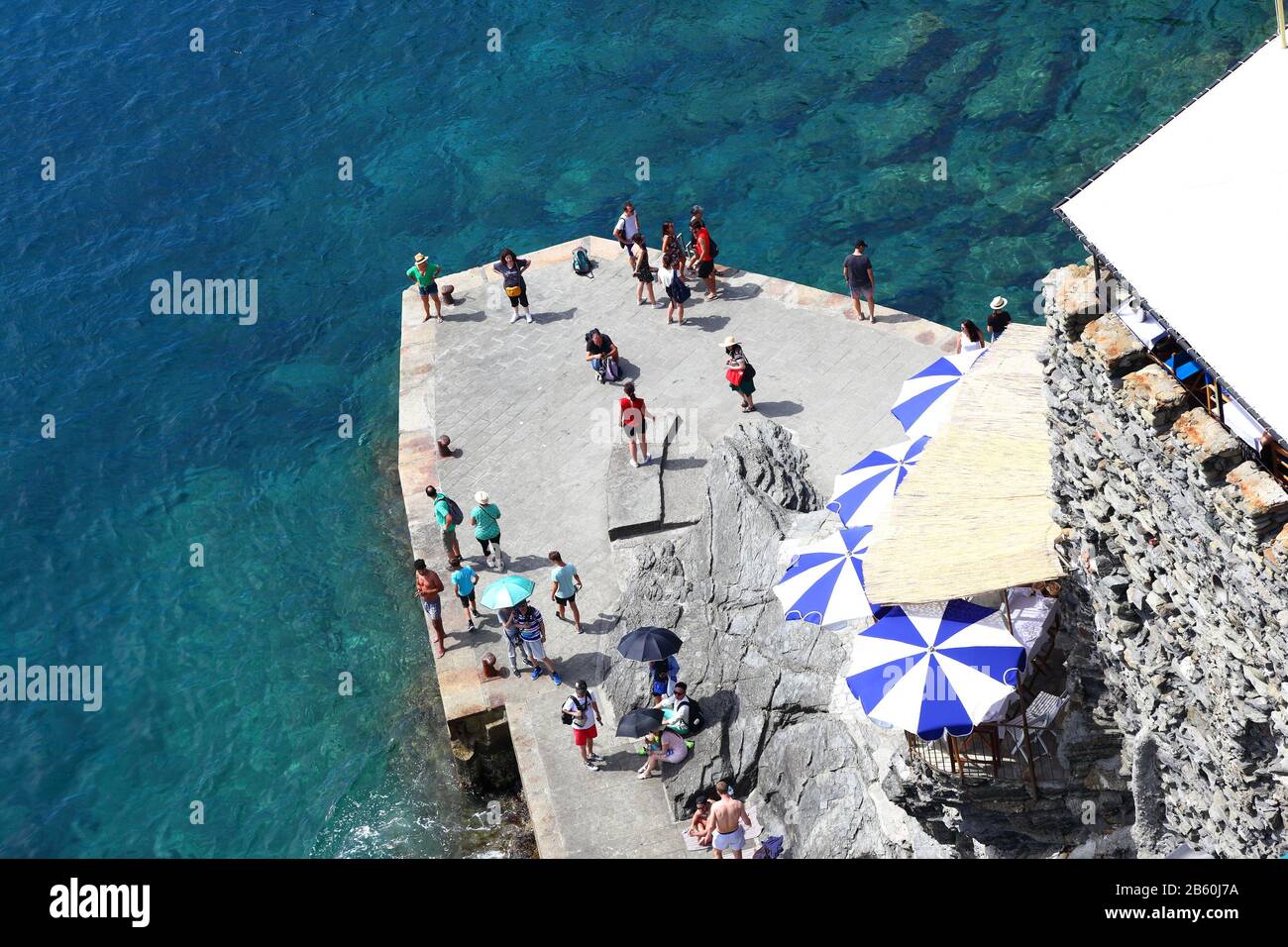 Éditorial - Vernazza, Cinque Terre- Italie 21.06.2019: Les touristes attendent le ferry au quai entouré d'eaux turquoise claires. Banque D'Images