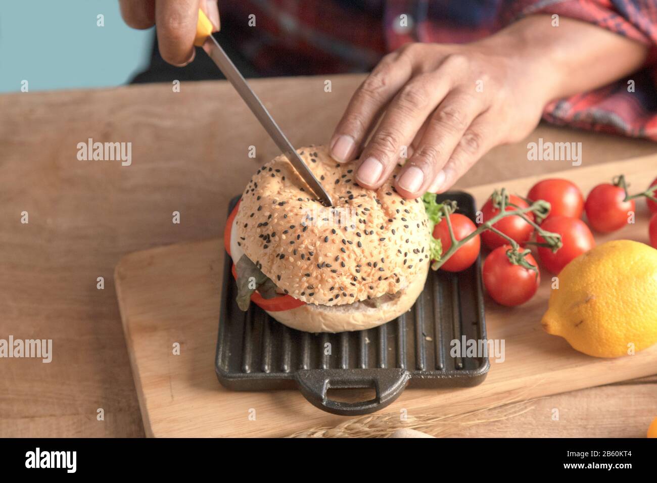 Le chef du maître d'hôtel utilise un hamburger à coupe de couteau fait maison dans la cuisine. Banque D'Images