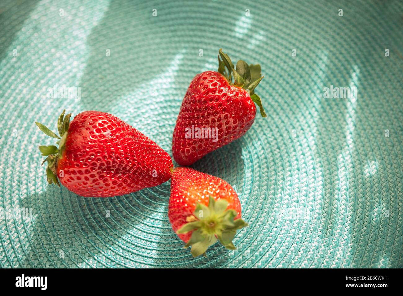 gros plan de fraises rouges rafraîchissantes sur une surface plane bleue Banque D'Images