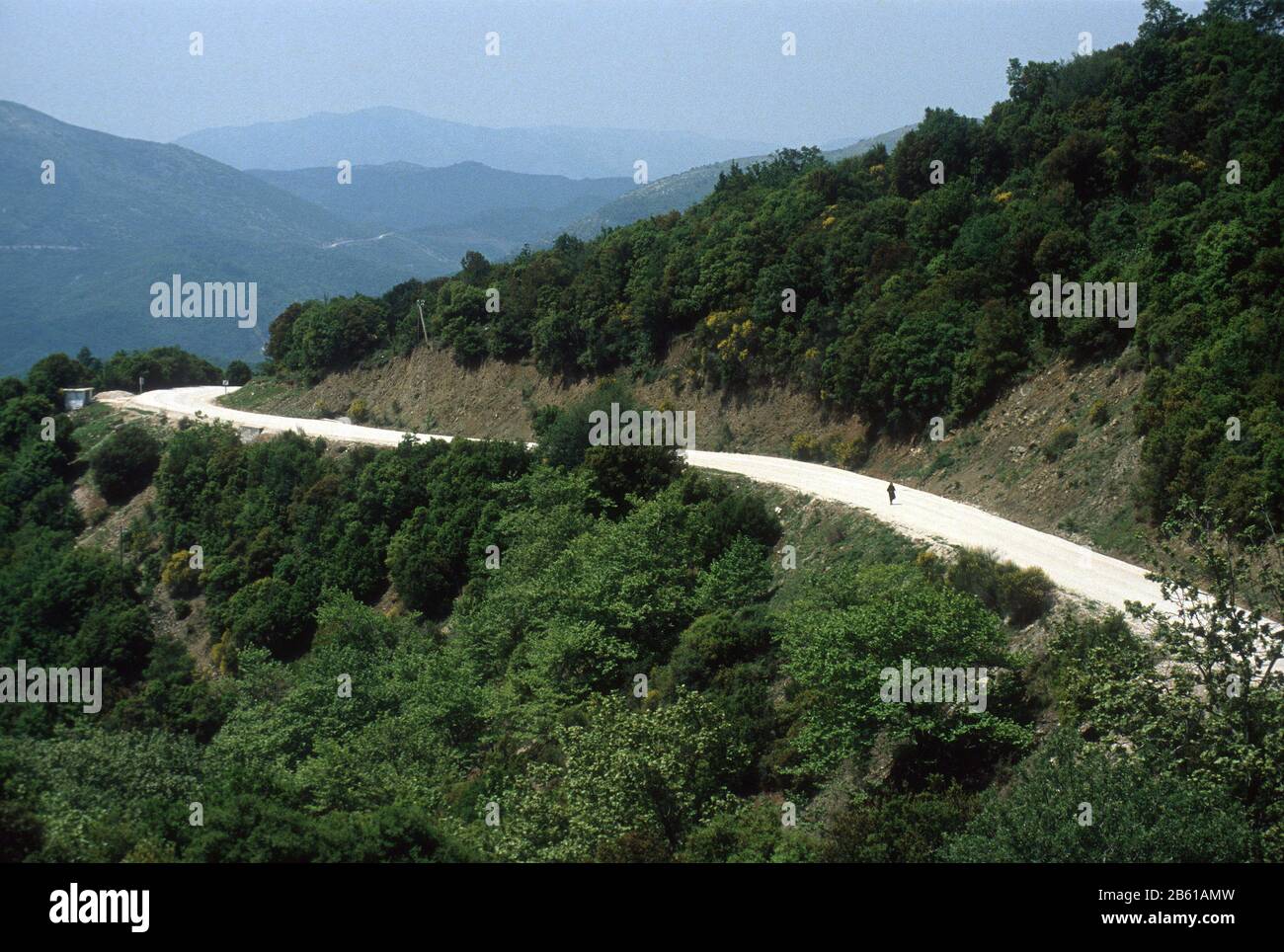 Une femme dans la robe traditionnelle, noire, grecque marche le long d'une route de montagne non faite près du village de Lia (Lias), Épire, Grèce, près de la frontière albanaise Banque D'Images