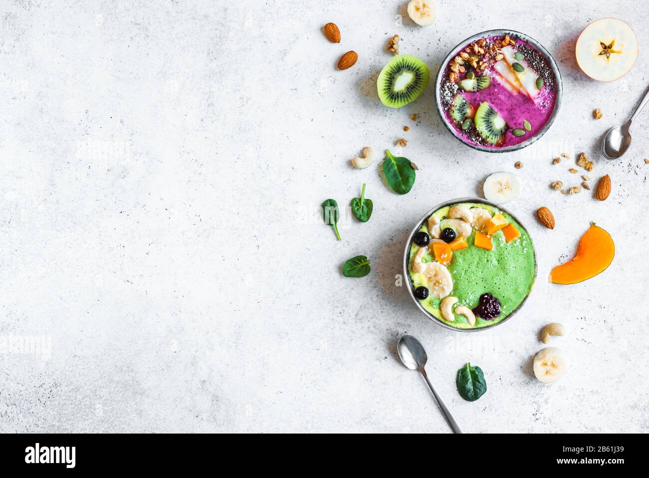 Smoothie Bowls colorés pour un petit-déjeuner sain, vue de dessus, espace de copie. Bols à smoothie aux épinards et aux baies verts avec divers garnitures. Mousse végétalienne brute Banque D'Images