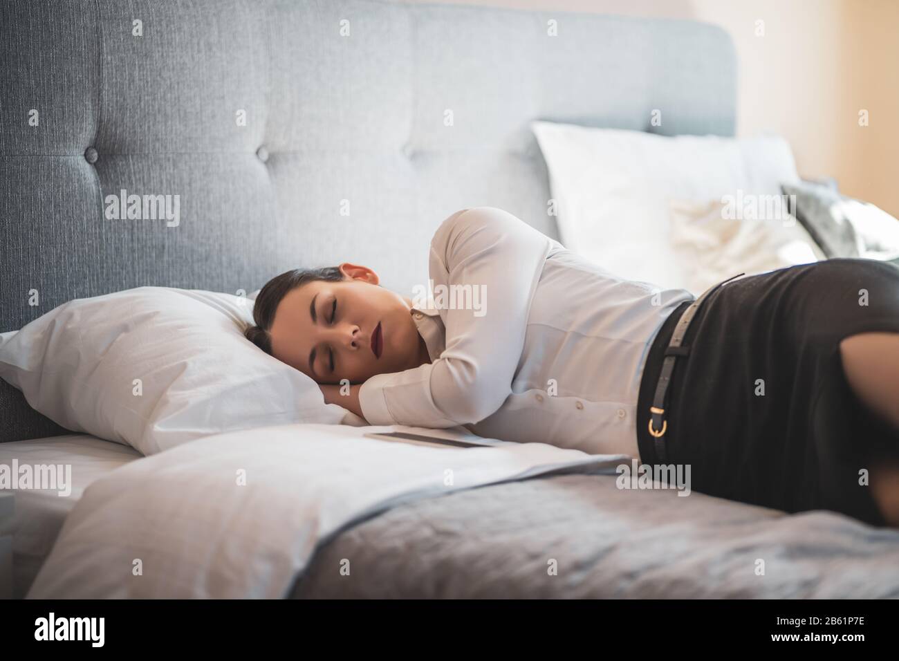 Une femme d'affaires fatiguée dore dans la chambre de l'hôtel. Banque D'Images