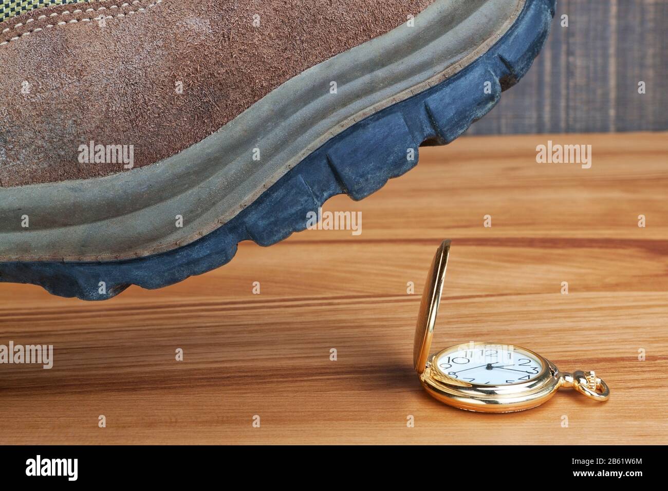 Temps de destruction de métaphore. Bottes sur la montre en or. Banque D'Images