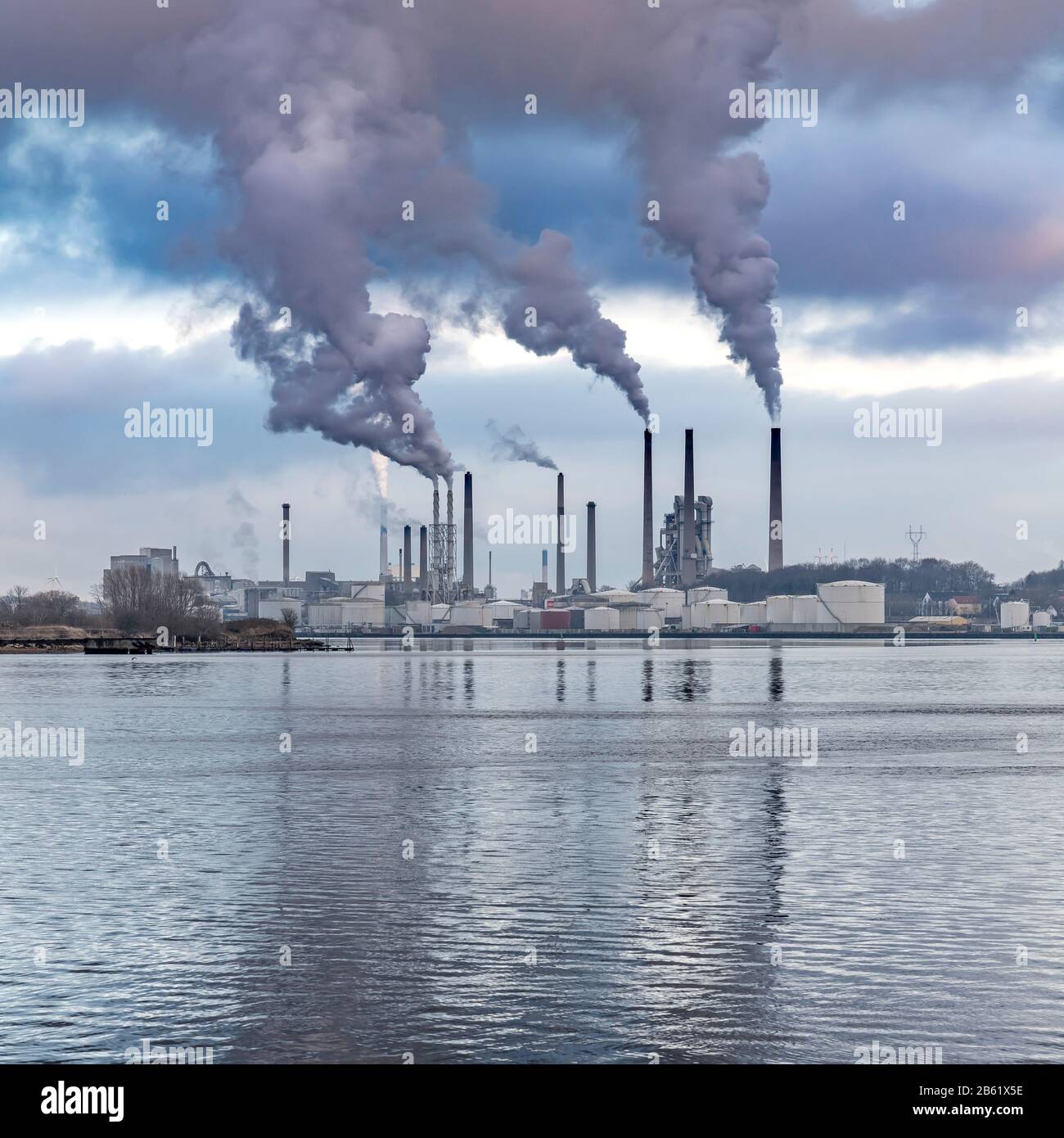 Zones industrielles au nord du Limfjord traversant le milieu d'Aalborg, Danemark. Des cheminées fumeurs sont à l'usine de ciment Portland. Banque D'Images
