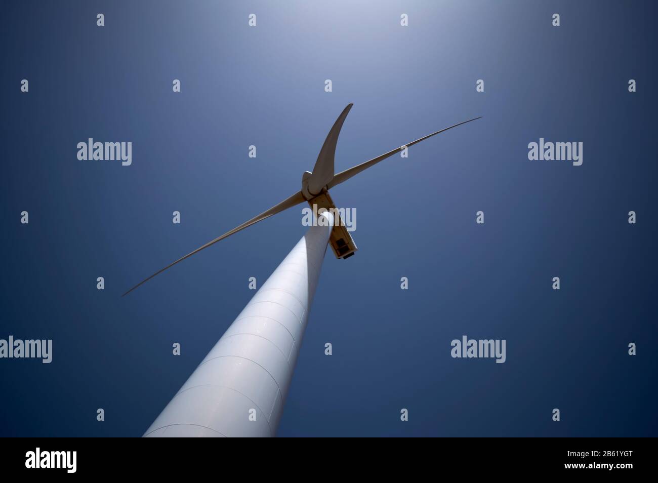 détail d'avion inférieur de la tour d'un moulin à vent avec ses pales sur une journée de ciel bleu Banque D'Images