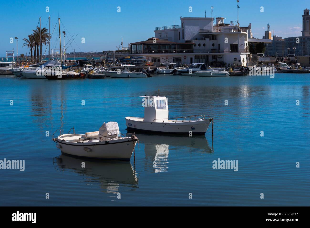 Bari, ITALIE - 16 FÉVRIER 2020: Deux petits bateaux sur l'eau calme sur fond de quai au port de pêche de Bari dans les Pouilles Banque D'Images