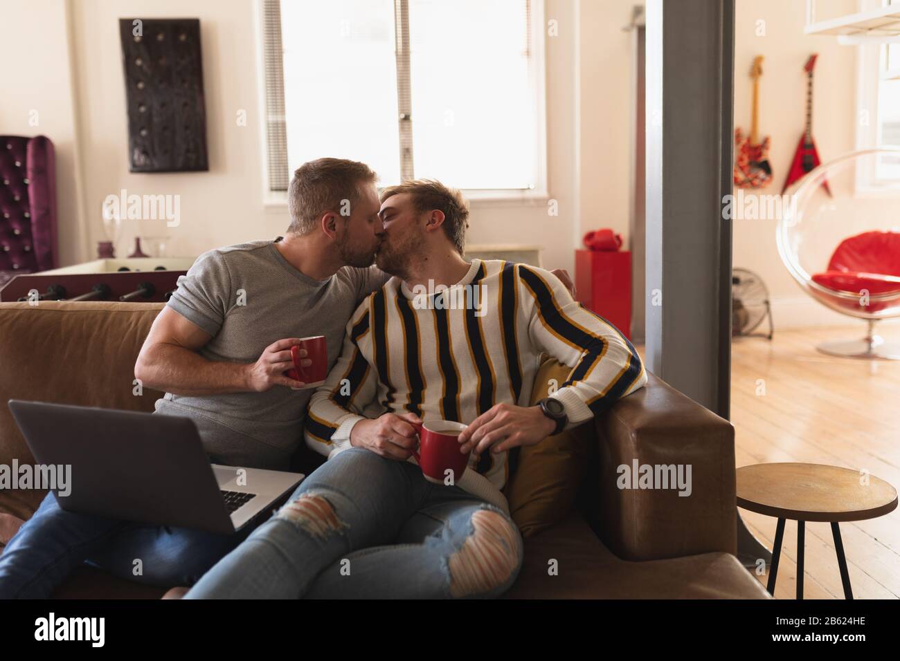 Couple homosexuel baiser sur le canapé Banque D'Images