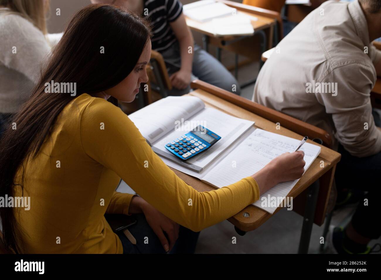 Vue en grand angle de l'écriture des étudiants en classe Banque D'Images