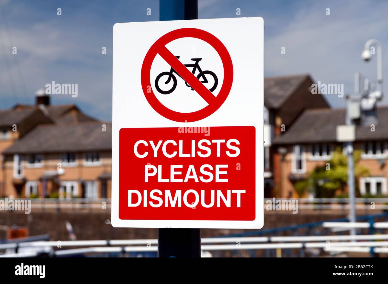 Les cyclistes s'il vous plaît démonter panneau, Penarth marina, Vale of Glamourgan, South Wales, Royaume-Uni. Banque D'Images