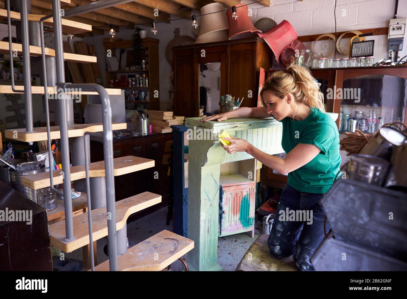 Femme En Atelier Upcyclisme Et Travail Sur Fire Surround Banque D'Images