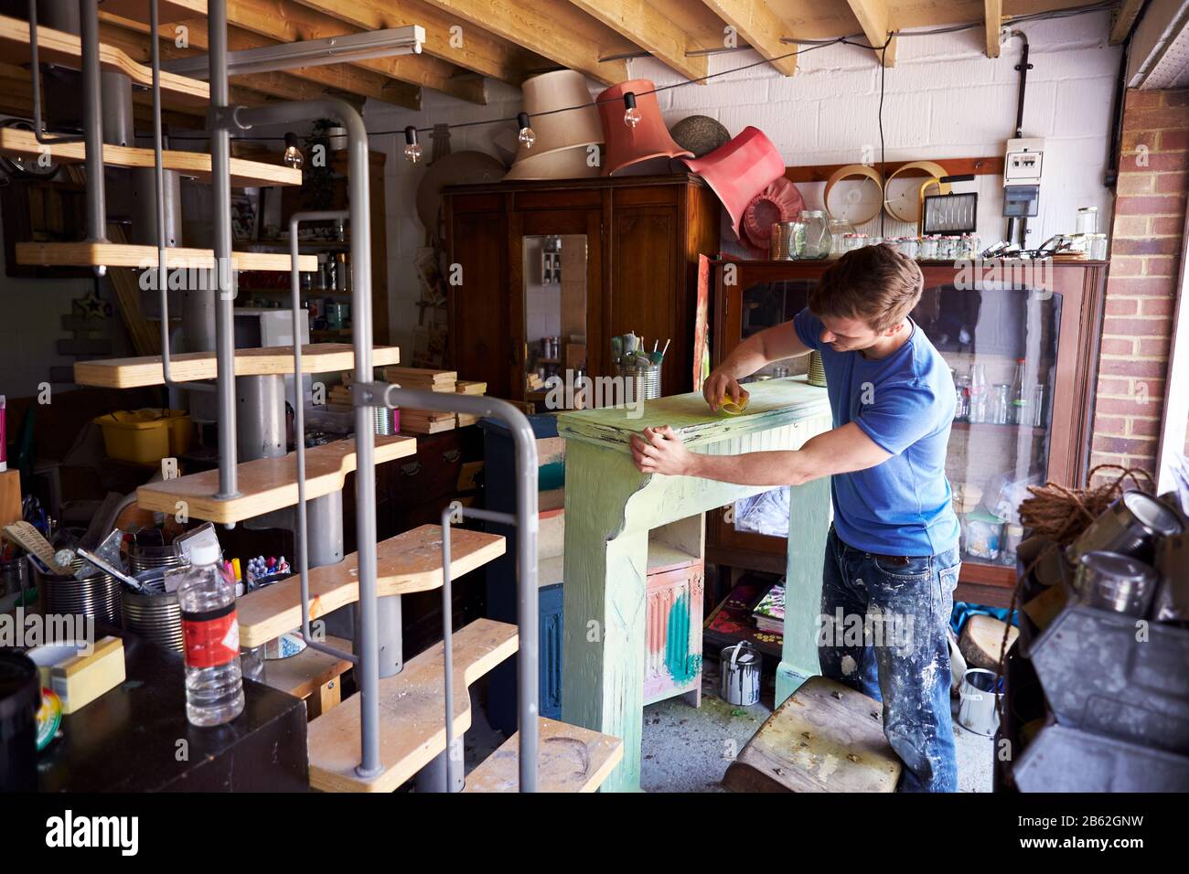 Homme En Atelier Upcyclisme Et Travail Sur Fire Surround Banque D'Images