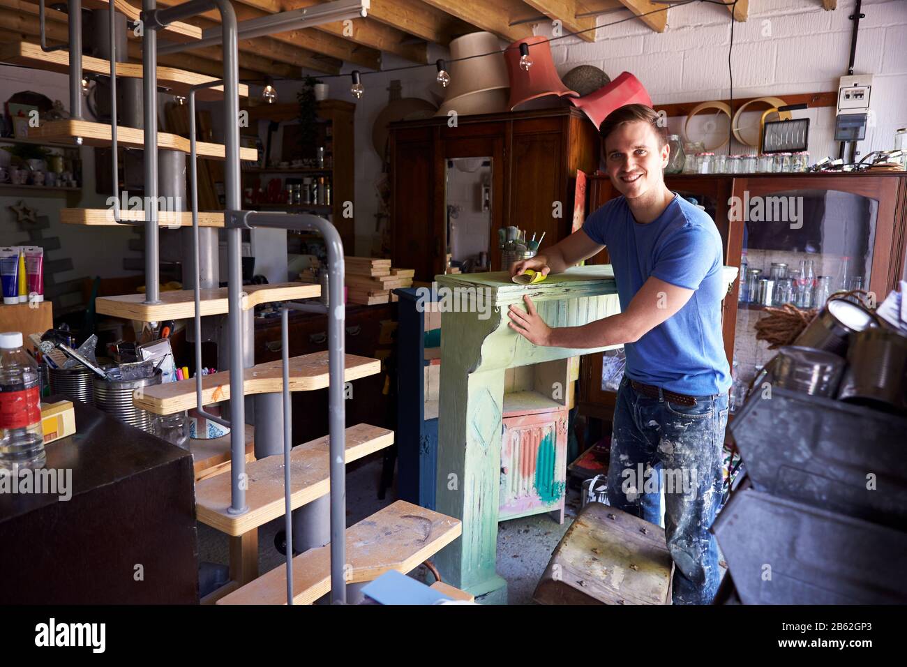 Portrait De L'Homme En Atelier Upcyclisme Et En Travaillant Sur Fire Surround Banque D'Images