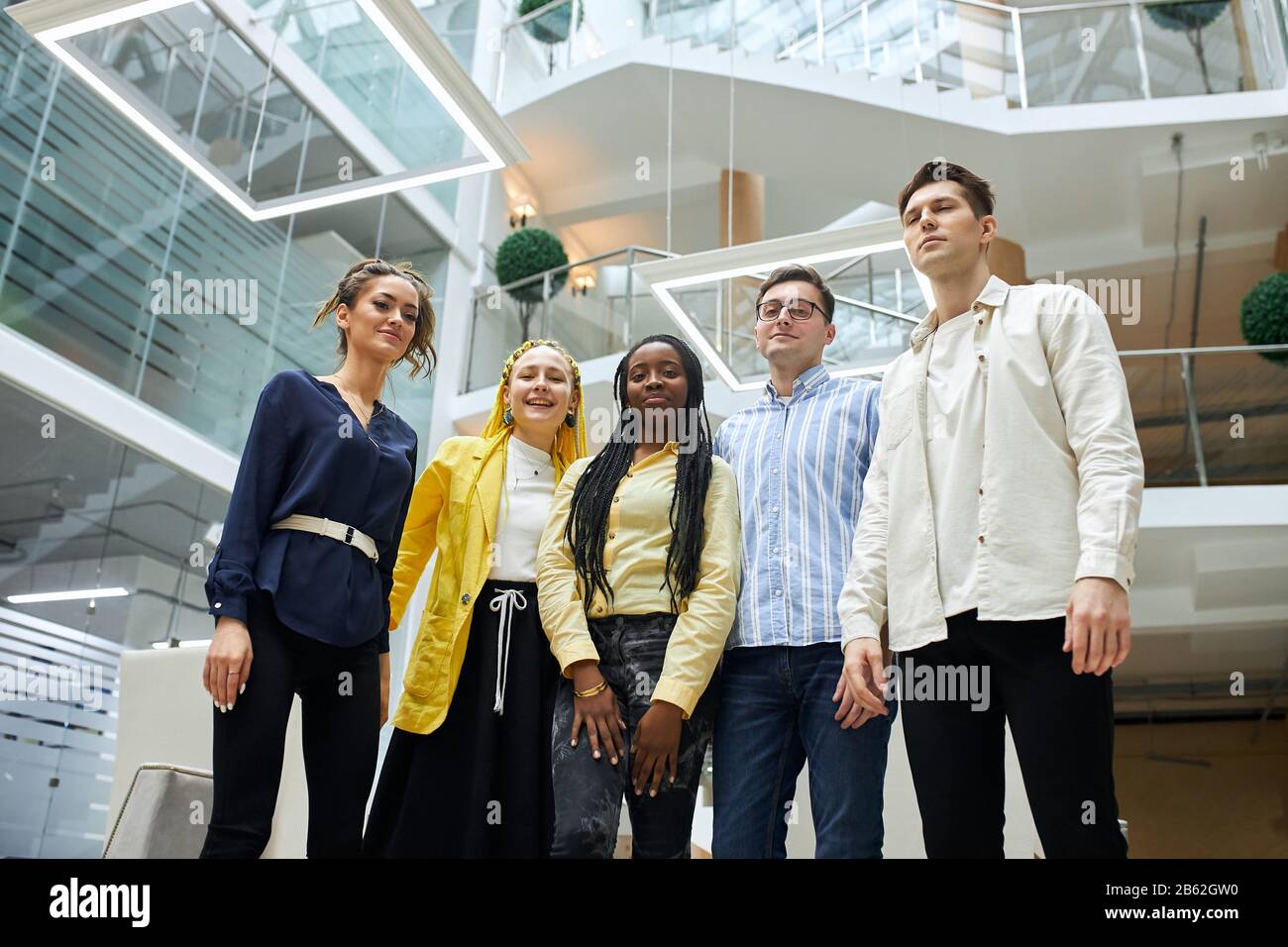 jeunes travailleurs de bureau séduisants posant à la caméra, ayant du temps libre, regardant la caméra . temps libre, style de vie, travail, profession. vue basse Banque D'Images