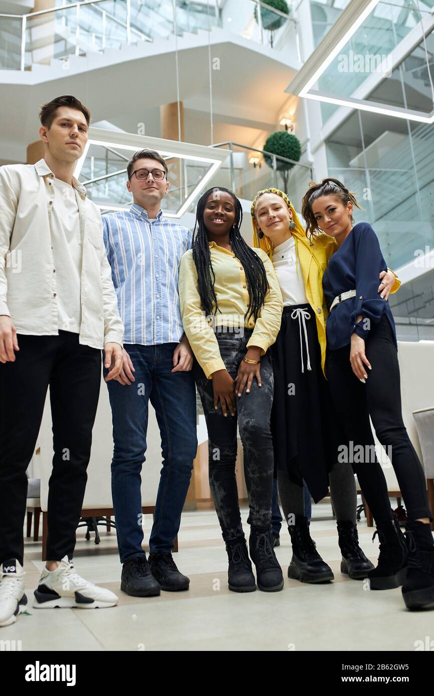 Portrait de groupe de jeunes gens d'affaires multiethniques souriant au bureau, photo pleine longueur, partenariat, équipe, amitié. Vue basse Banque D'Images