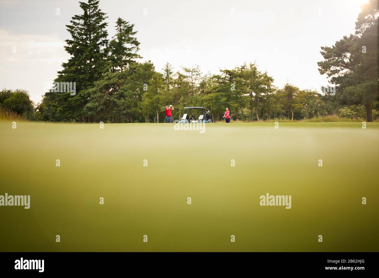 Photo À Angle Bas De Couple Avec Buggy Playing Round Of Golf Banque D'Images
