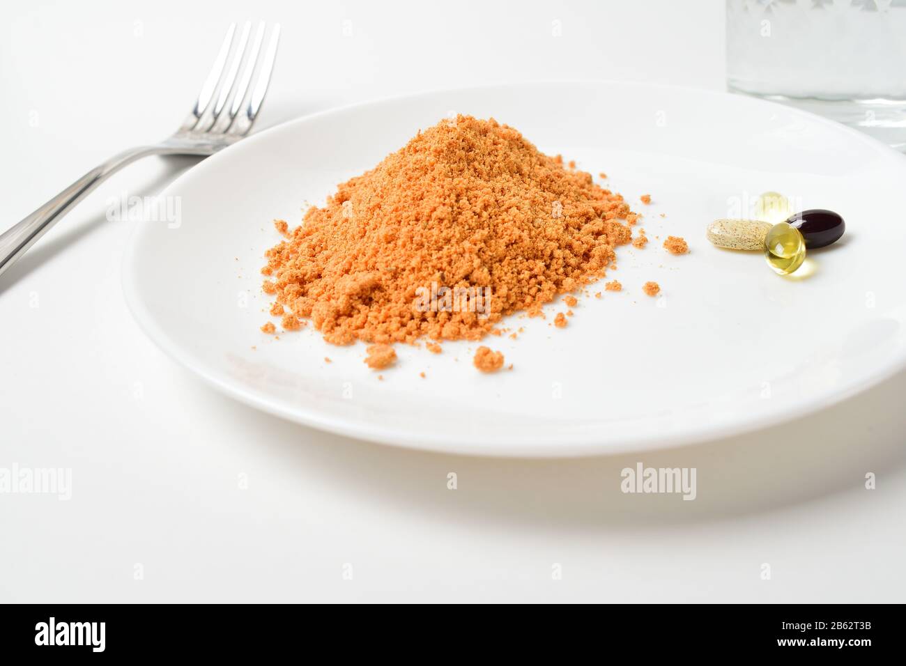 Remplacement de repas. Soupe sèche. Soupe aux protéines de tomate en poudre et multivitamines sur une plaque. Multivitamines, astaxanthine, huile de poisson, comprimés oméga. Banque D'Images