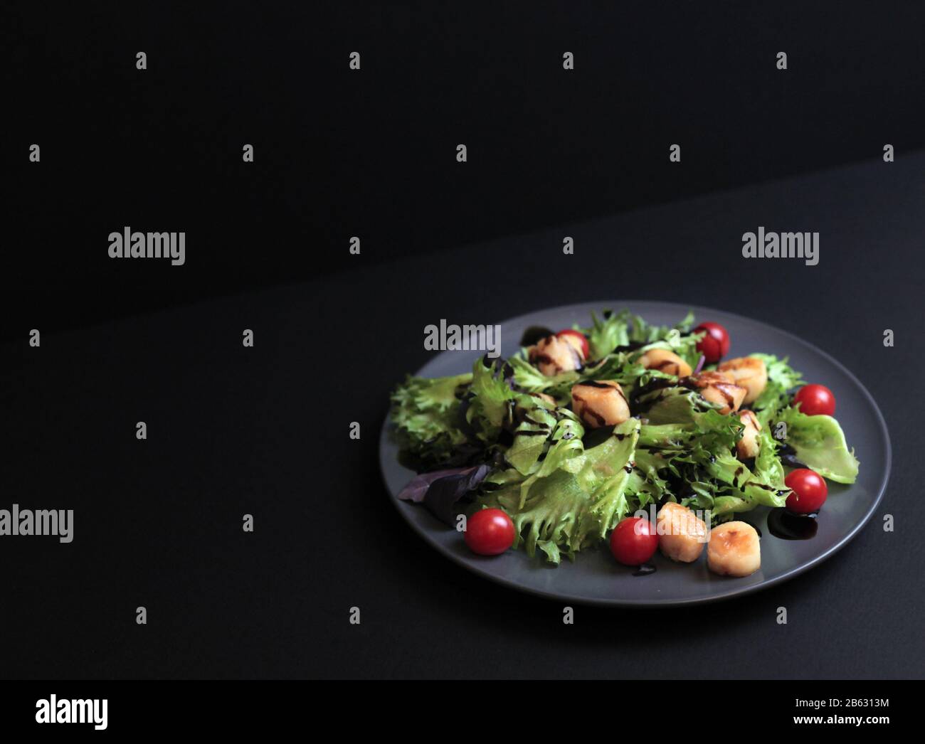 Salade de pétoncles de mer frais avec concombre sur fond sombre. Mise au point sélective Banque D'Images