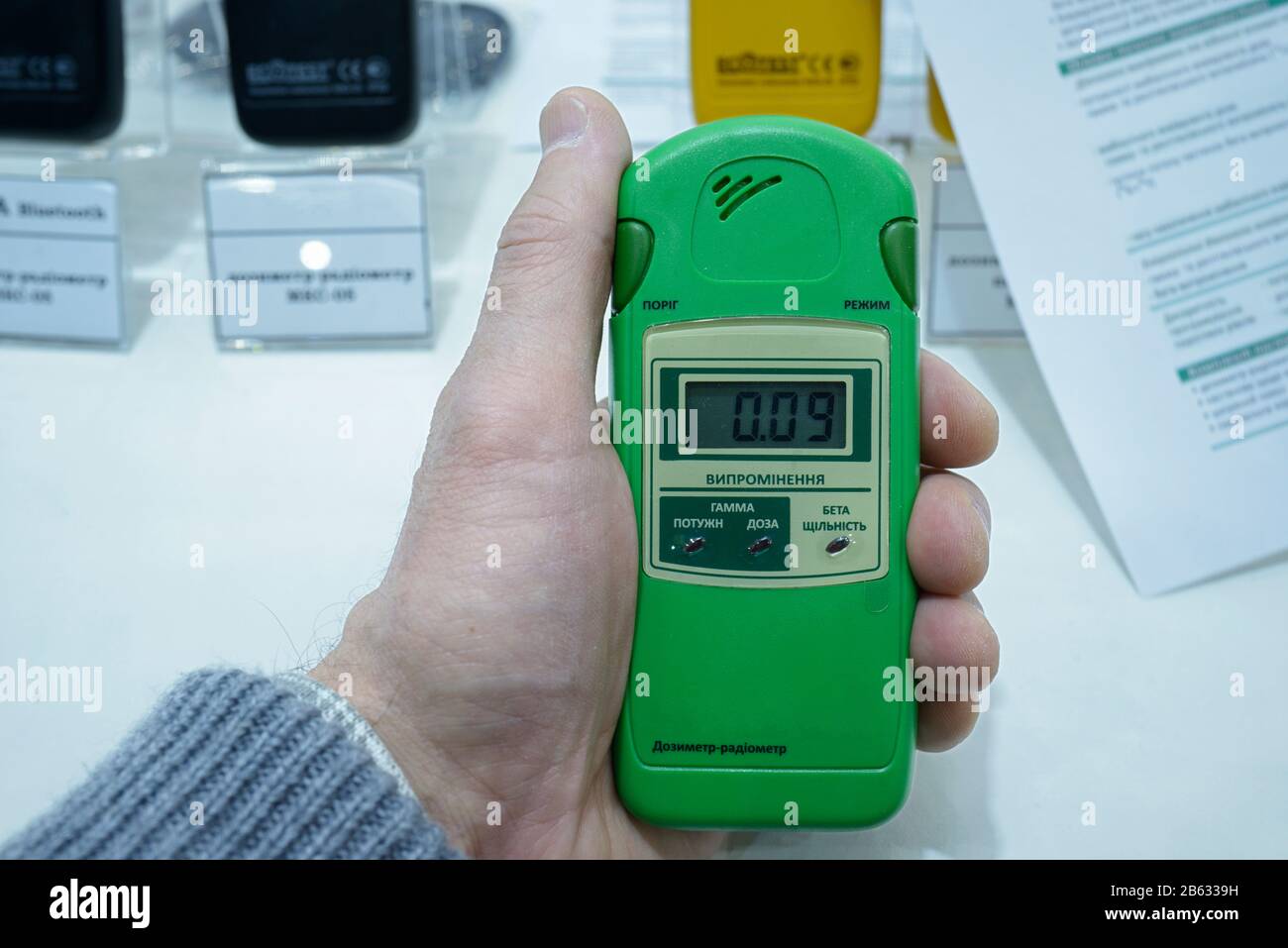 Main du client tenant des dosimètres-radiomètres personnels pro pour mesurer les niveaux de rayonnement Banque D'Images
