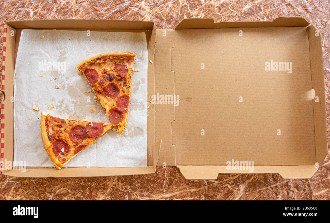 Rassis, restes de tranches de pizza dans la boîte de livraison de pizza Banque D'Images