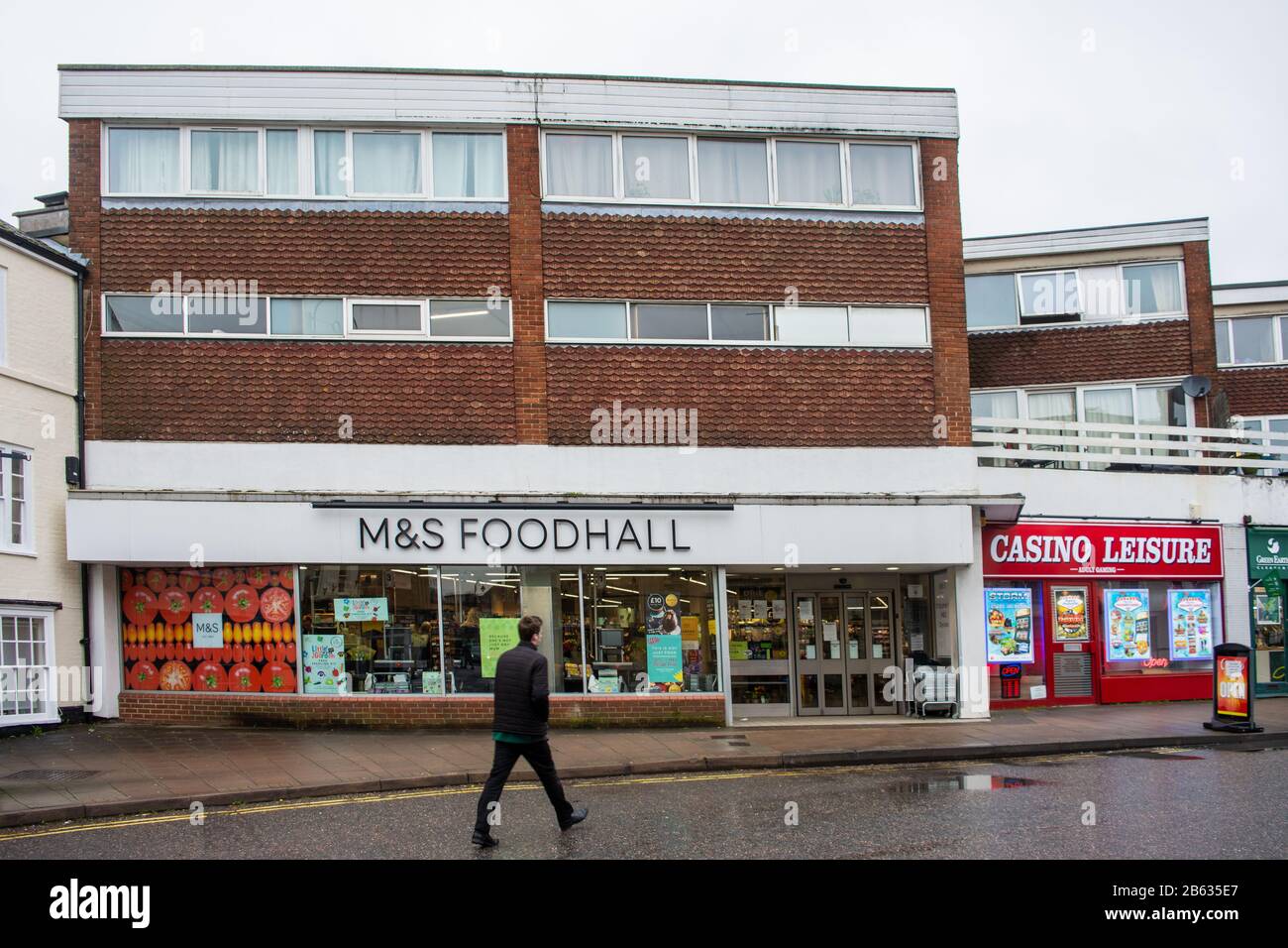Un magasin M&S Foodhall sous des appartements résidentiels avec un mouvement piéton flou passant par Banque D'Images