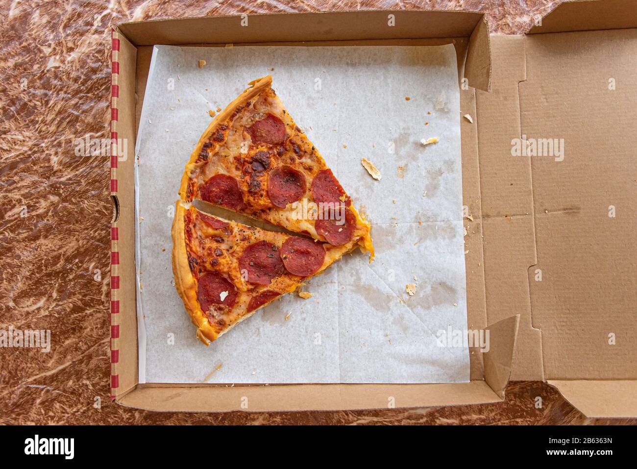 Rassis, restes de tranches de pizza dans la boîte de livraison de pizza Banque D'Images