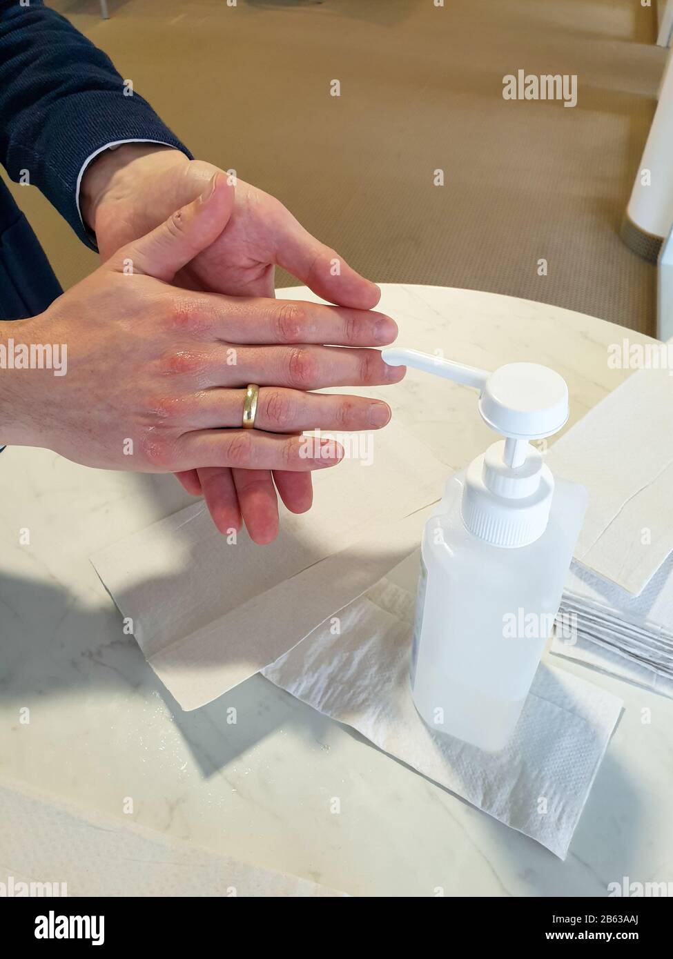 L'homme marié avec l'anneau doré sur le doigt se lave les mains avec du désinfectant pour éviter d'être infecté par le virus corona. Banque D'Images