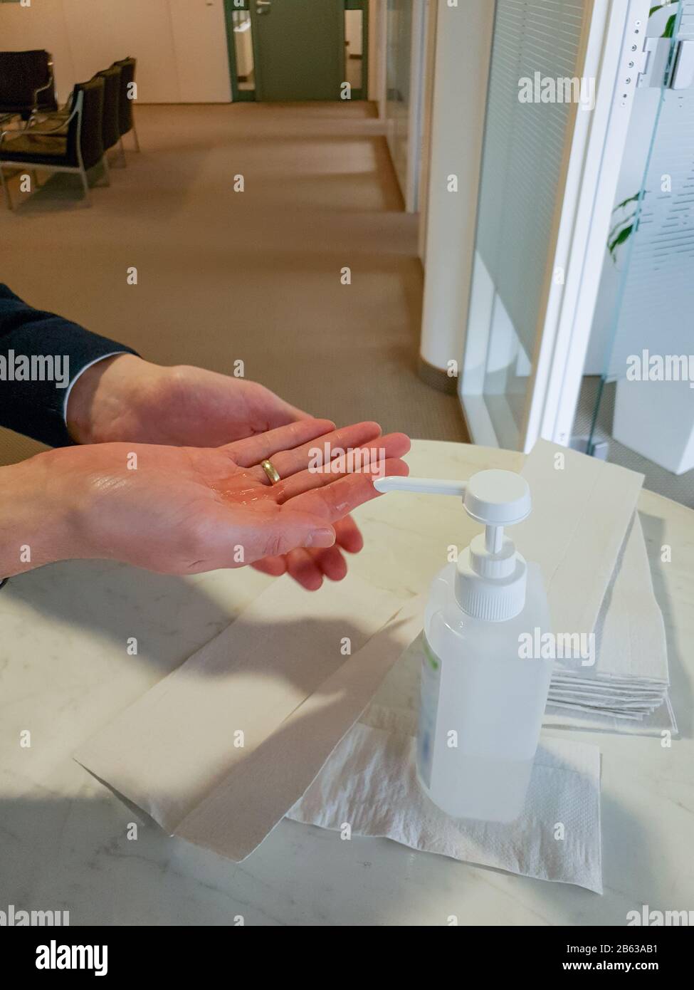 L'homme marié avec l'anneau doré sur le doigt se lave les mains avec du désinfectant pour éviter d'être infecté par le virus corona. Banque D'Images