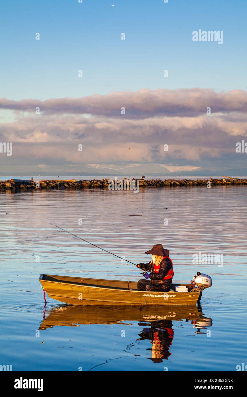 Pêcheur solitaire dans un bateau en aluminium au lever du soleil à Steveston Harbour Colombie-Britannique Canada Banque D'Images